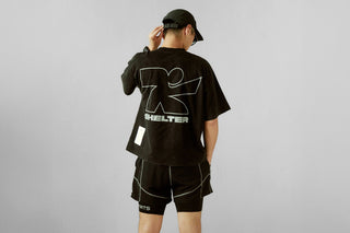 Runner in a cap and black Shelter graphic tee, seen from behind