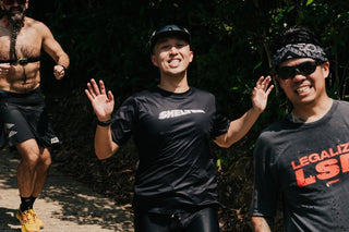 Shelter runners smiling mid-run on a trail