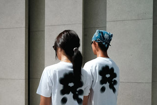 Two runners in white Shelter tees against a concrete wall
