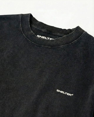 Black t-shirt with 'SHELTER' logo on a white background